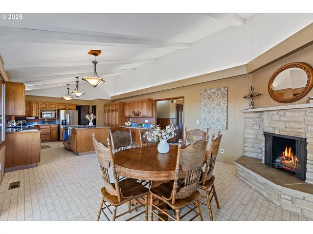 a dining room with furniture a fireplace and wooden floor