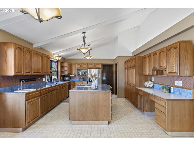 a kitchen with stainless steel appliances kitchen island granite countertop a sink counter space and cabinets