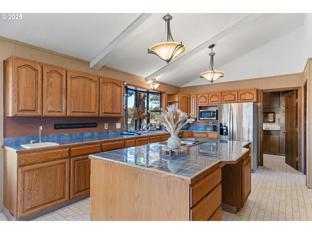 a kitchen with stainless steel appliances granite countertop a sink a stove and a refrigerator