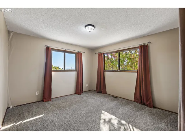 an empty room with windows and closet