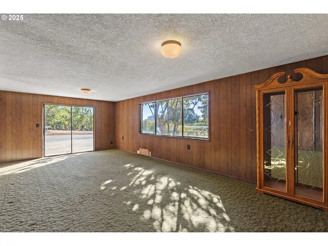a view of an empty room with a fireplace and a window