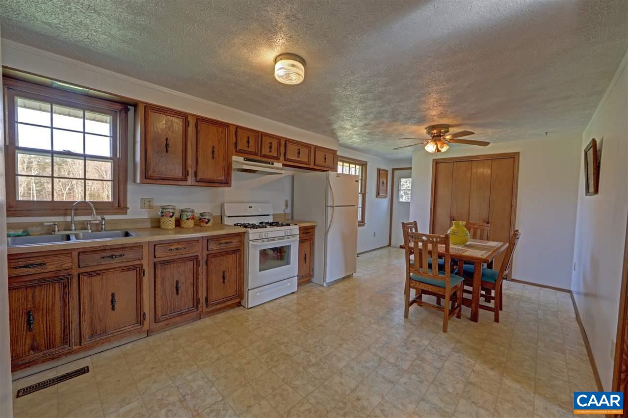 869 Black Cat Road Keswick, VA 22947 - Photo 9 of 20 a kitchen with refrigerator cabinets dining table and chairs
