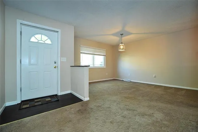 an empty room with windows and cabinet