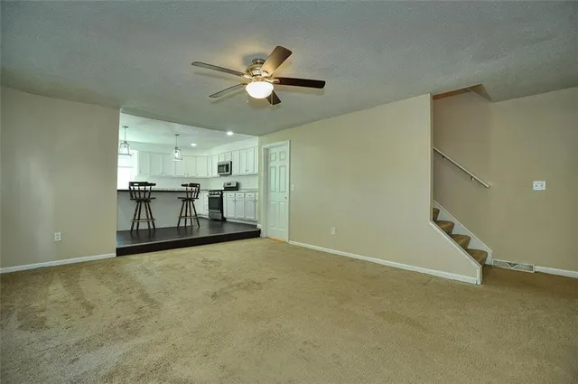 a view of a livingroom with a furniture chandelier fan and windows