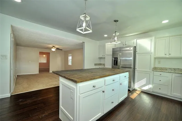a bathroom with a granite countertop sink and a refrigerator