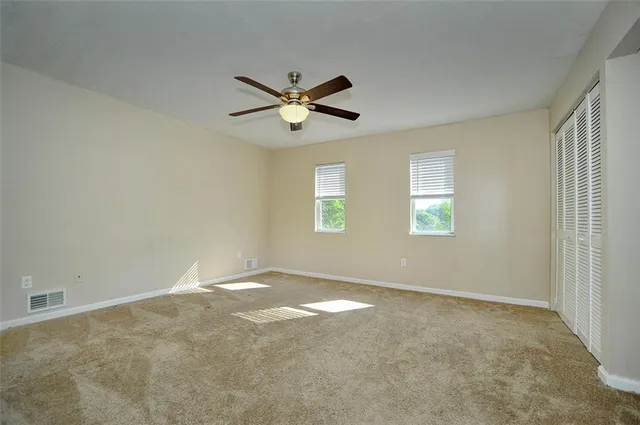 an empty room with a window and a fan