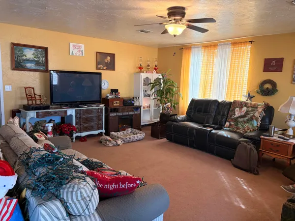 a living room with furniture a flat screen tv and a window