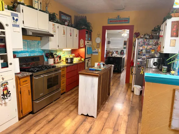 a kitchen with stainless steel appliances granite countertop a stove a sink dishwasher and a refrigerator