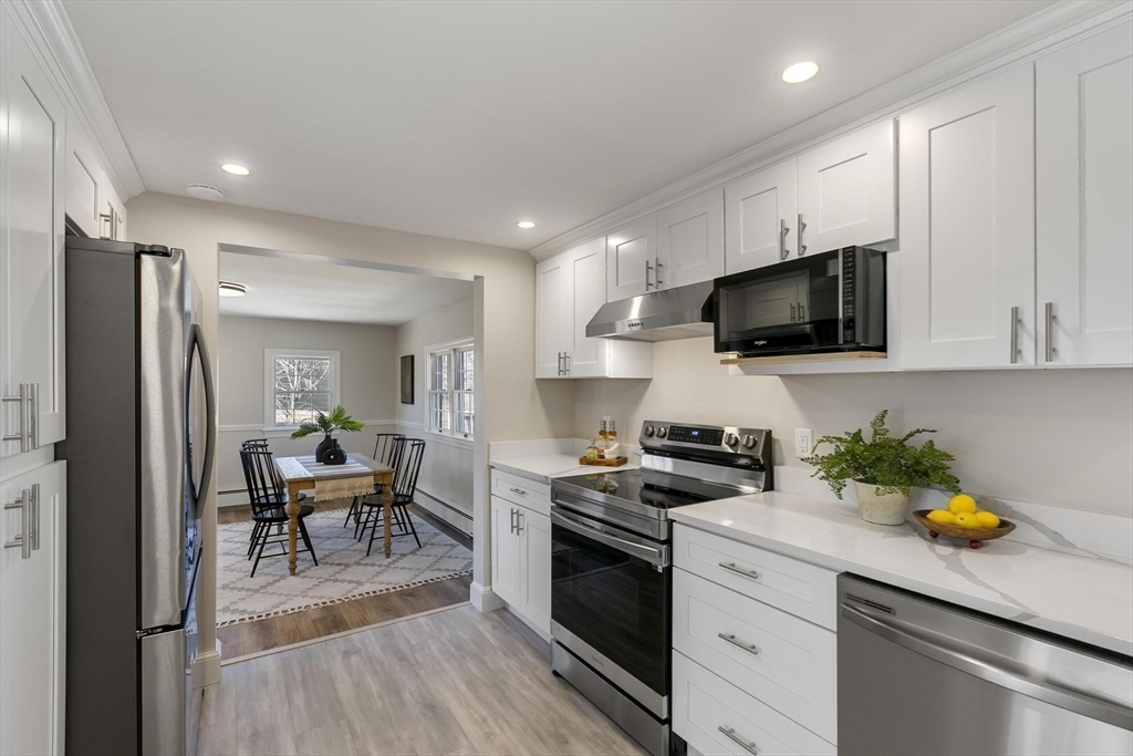 8 Crosby Road Reading, MA 01867 - Photo 12 of 30 a kitchen with stainless steel appliances a stove a sink a microwave a refrigerator and cabinets