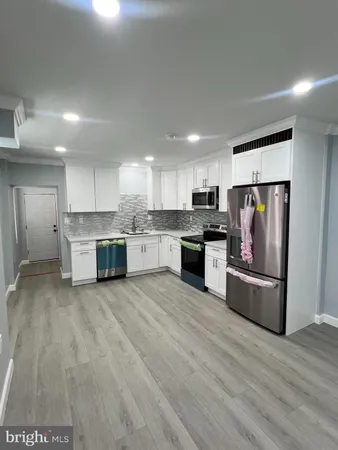 a large kitchen with stainless steel appliances granite countertop a stove and a refrigerator