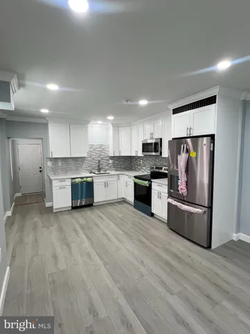 a large kitchen with stainless steel appliances granite countertop a stove and a refrigerator