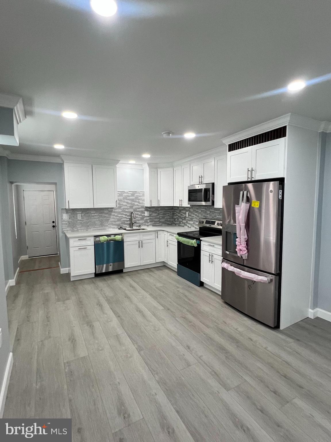 a large kitchen with stainless steel appliances granite countertop a stove and a refrigerator