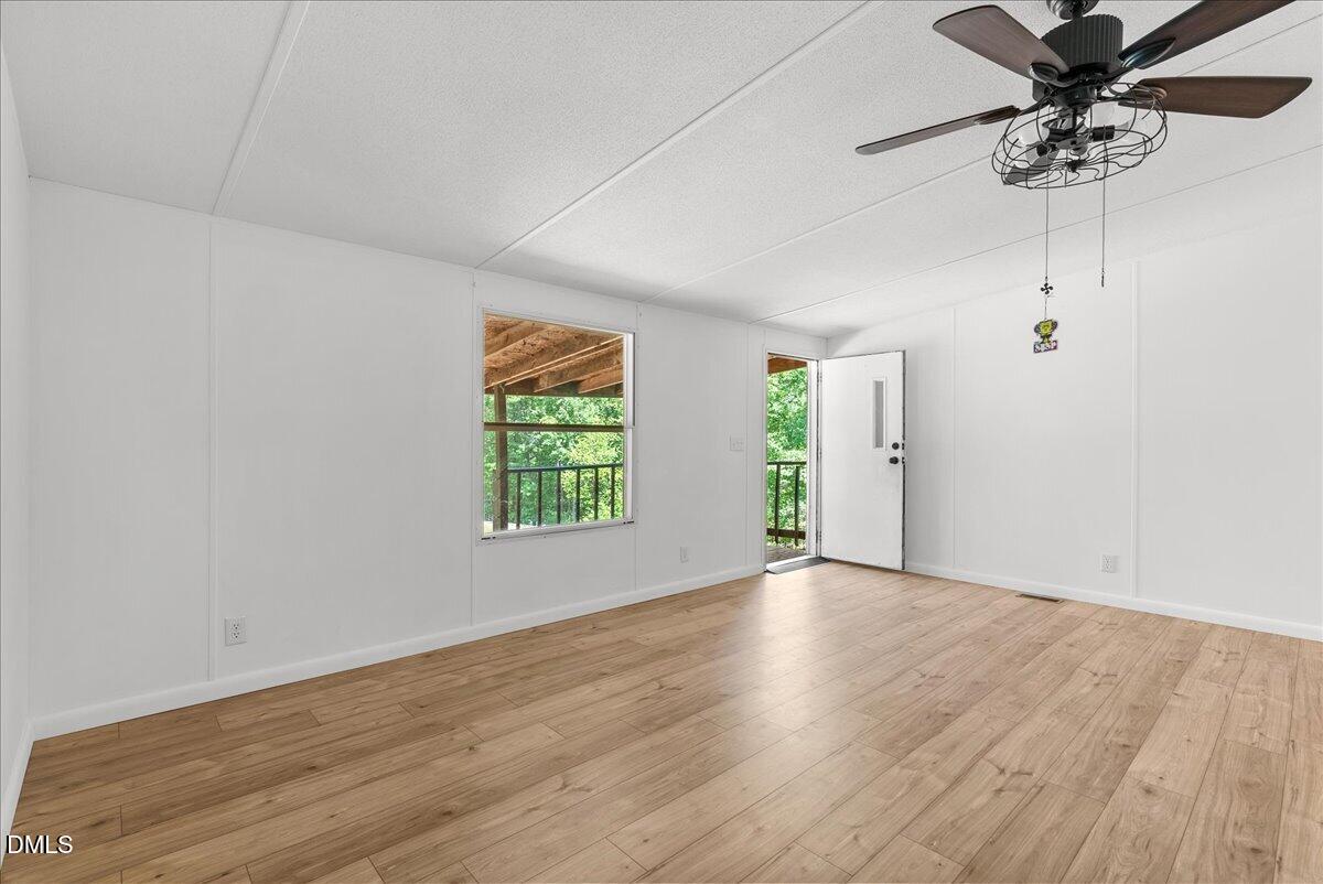 1111 Stoney Mountain Road Rougemont, NC 27572 - Photo 20 of 30 an empty room with wooden floor fan and windows