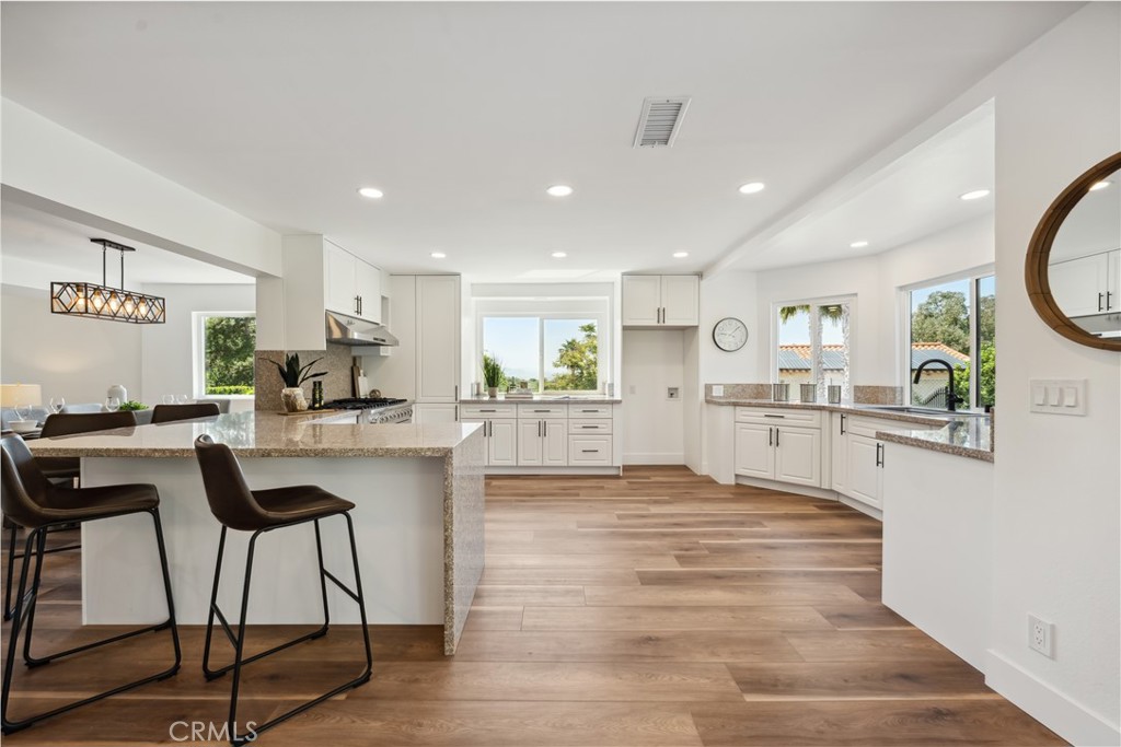 529 Manzanita Road Redlands, CA 92373 - Photo 18 of 64 a kitchen with stainless steel appliances kitchen island granite countertop white cabinets and wooden floor