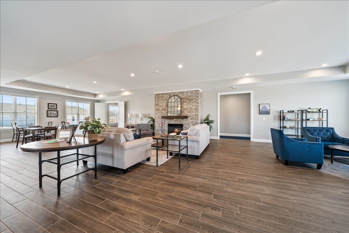 415 Abbey Road, Unit D Munford, TN 38058 - Photo 30 of 35 Expansive open-concept living area featuring wood-finish flooring, a brick fireplace with a mantel, recessed lighting, and multiple large windows