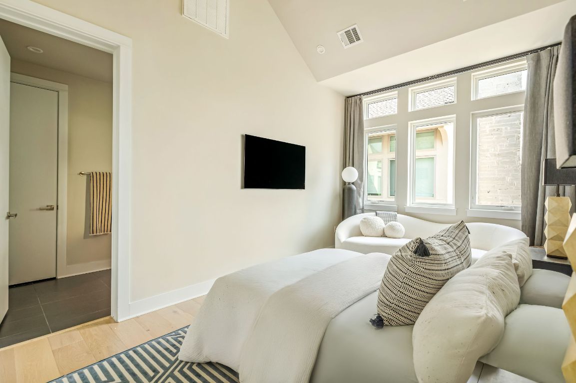 2300 Enfield Road, Unit 302 Austin, TX 78703 - Photo 12 of 26 a bedroom with a bed and wooden floor