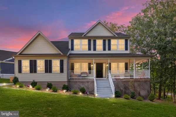 a front view of a house with a yard and green space