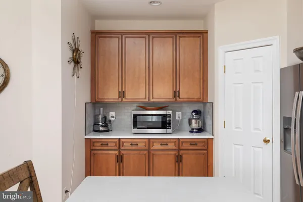 a kitchen with stainless steel appliances wooden floors cabinets and a window