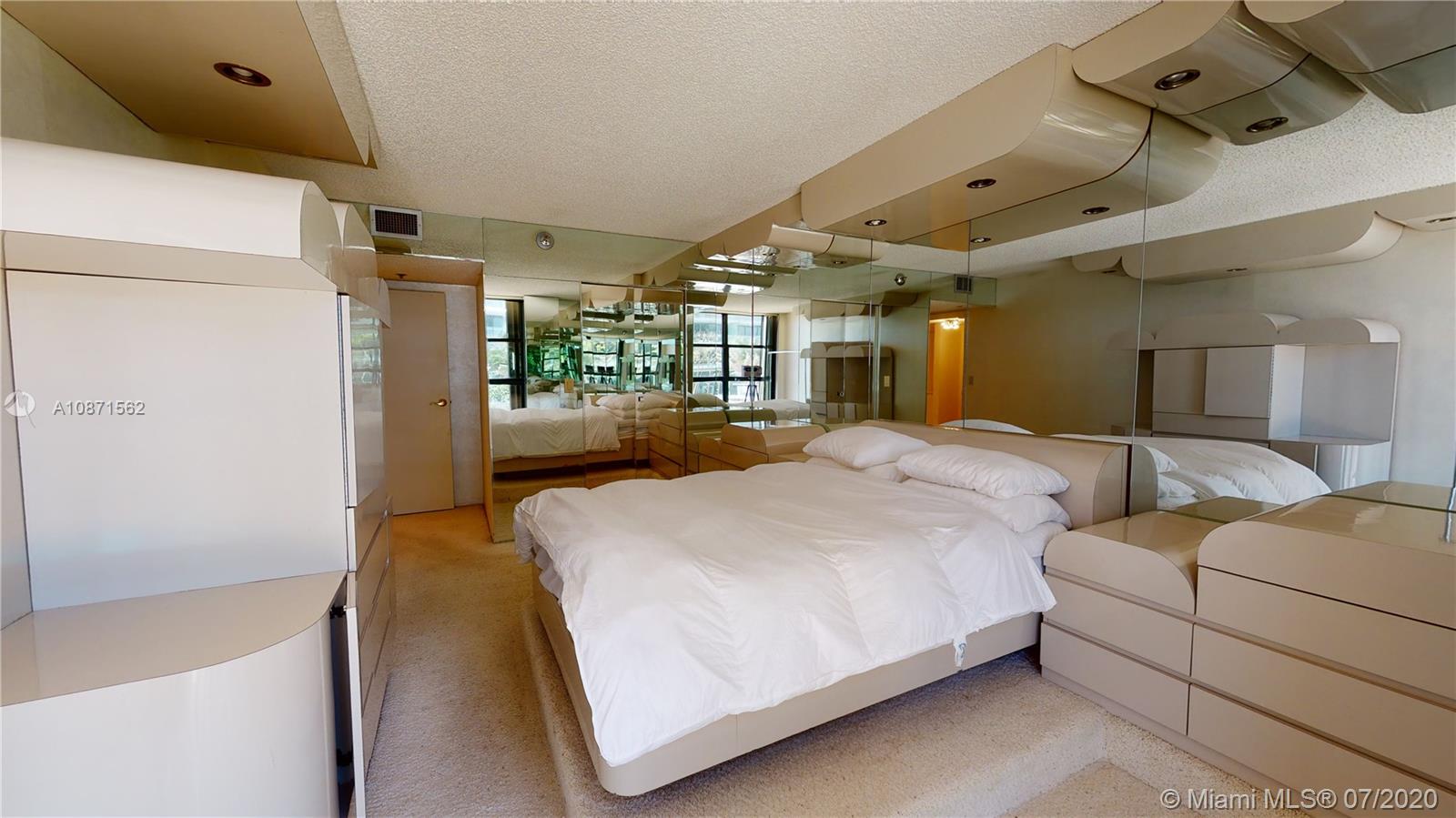 Normandy Beach Surfside, FL 33154 - Photo 16 of 18 a large bedroom with a bed and a large mirror on the dresser