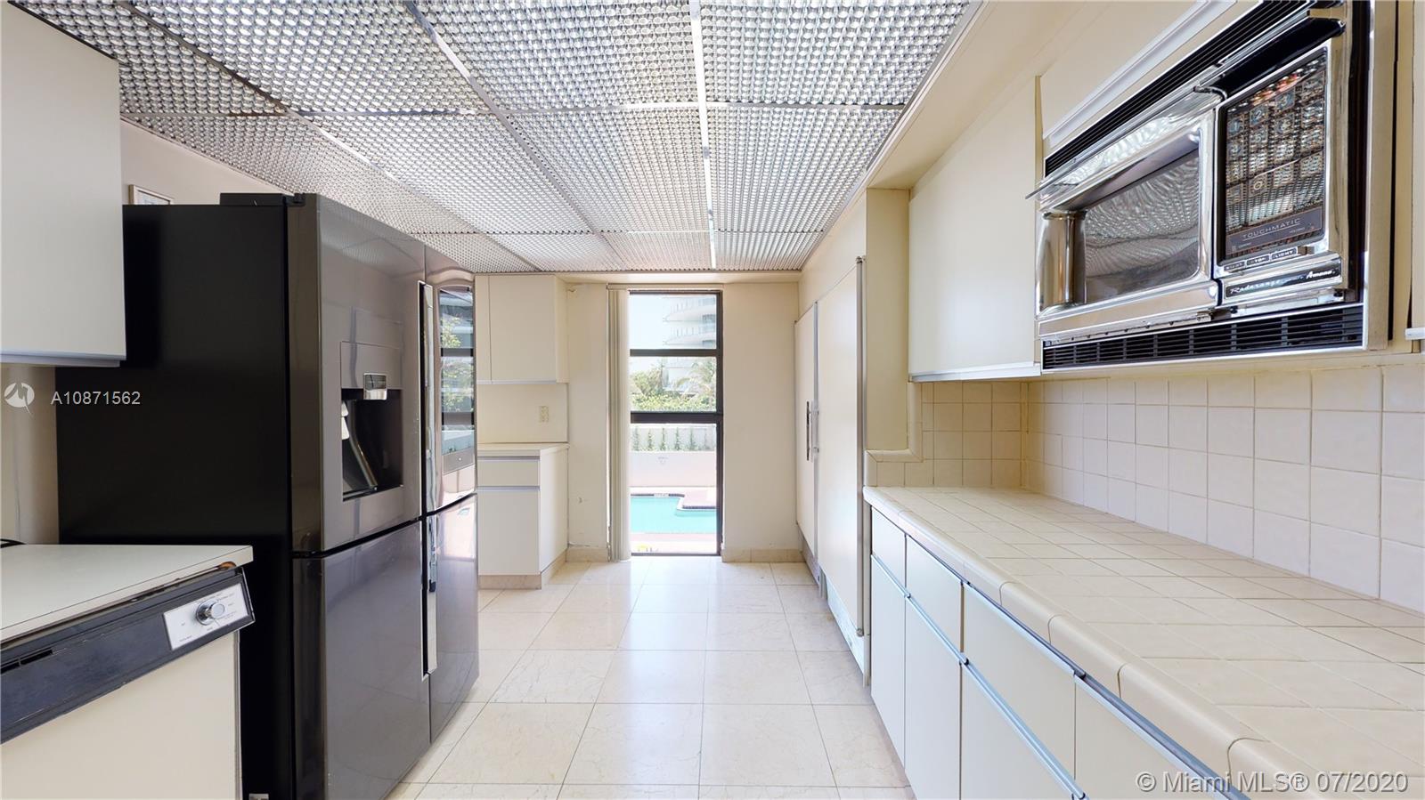 Normandy Beach Surfside, FL 33154 - Photo 10 of 18 a kitchen with stainless steel appliances granite countertop a refrigerator and a sink