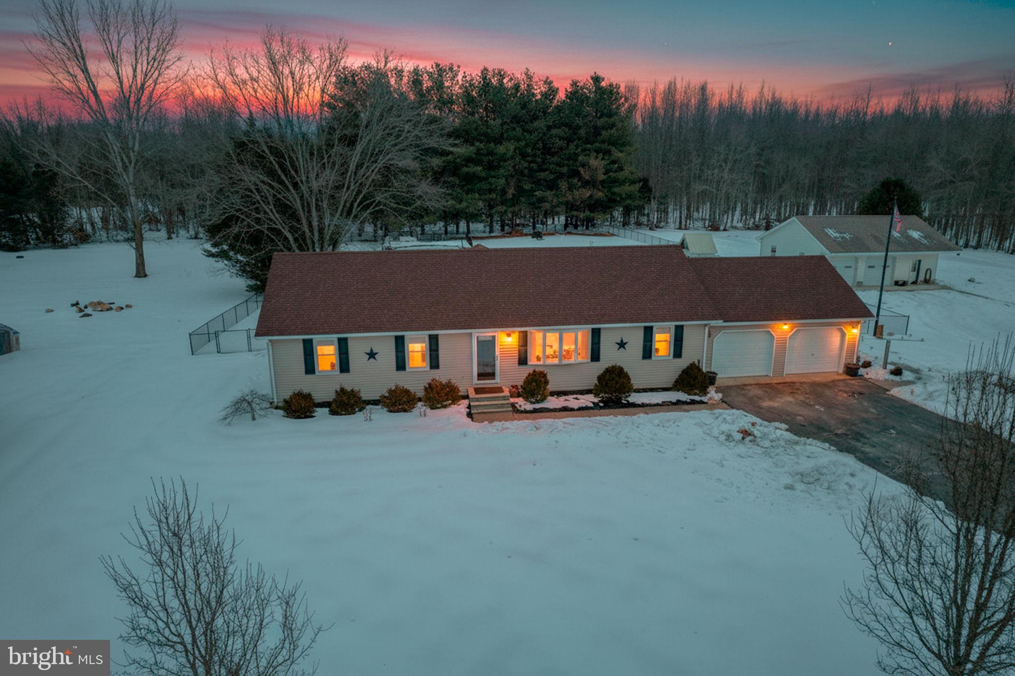 a view of house with yard and trees in the background