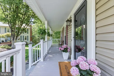 a view of a hallway with wooden floor and stairs