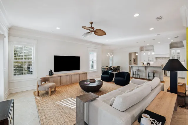a living room with furniture a flat screen tv and a large window