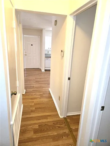 a view of a hallway with wooden floor and staircase