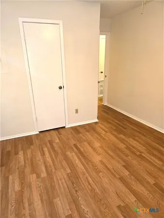 an empty room with wooden floor and a window