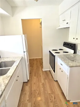 a kitchen with a sink stove and refrigerator