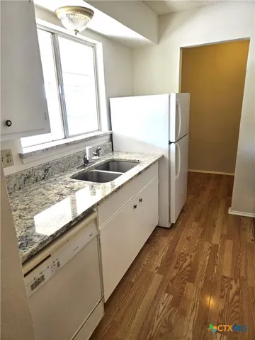 a bathroom with a granite countertop sink a mirror and a shower