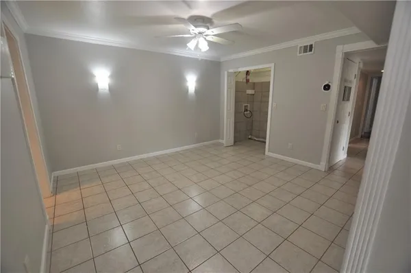a view of an empty room with a window and a chandelier fan