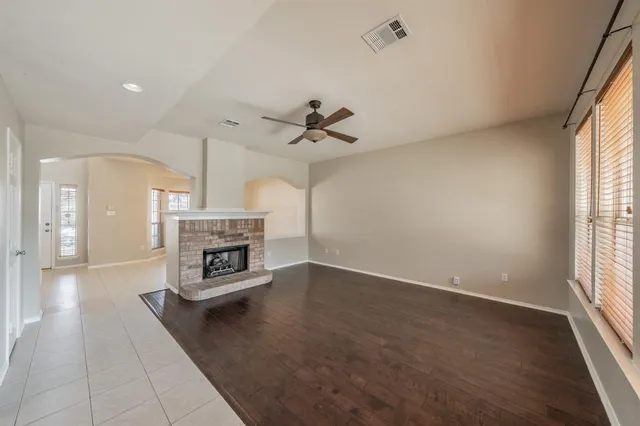 an empty room with windows and a fireplace