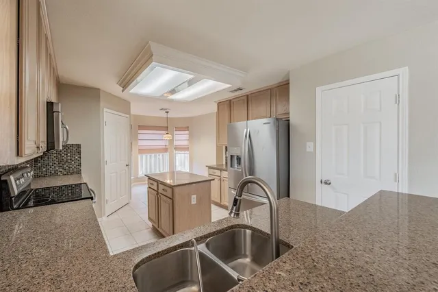 a kitchen with stainless steel appliances granite countertop a refrigerator and a sink