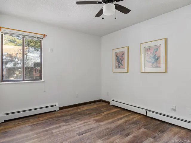 a view of empty room with wooden floor and window