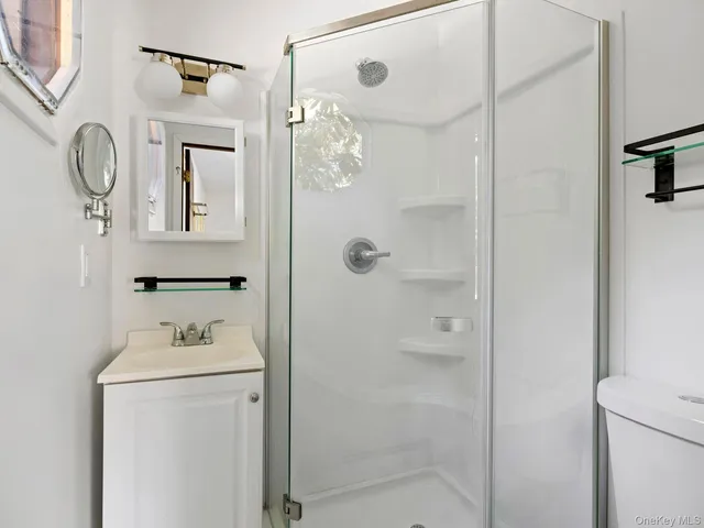 a bathroom with a shower a mirror and a sink