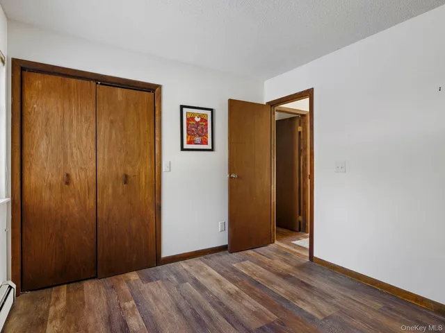 a view of a hallway with wooden floor and closet