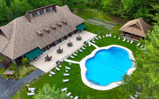 a view of a swimming pool with lawn chairs under an umbrella
