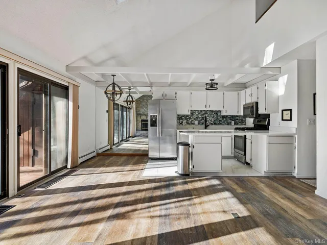 a kitchen with a refrigerator and white cabinets