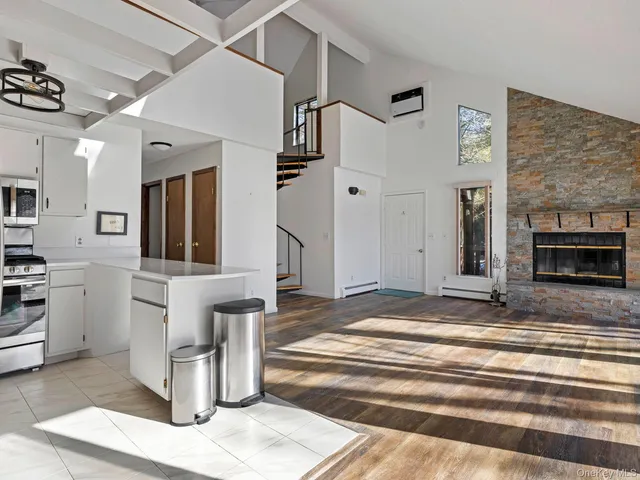 a view of a hallway with stainless steel appliances granite countertop furniture and a fireplace