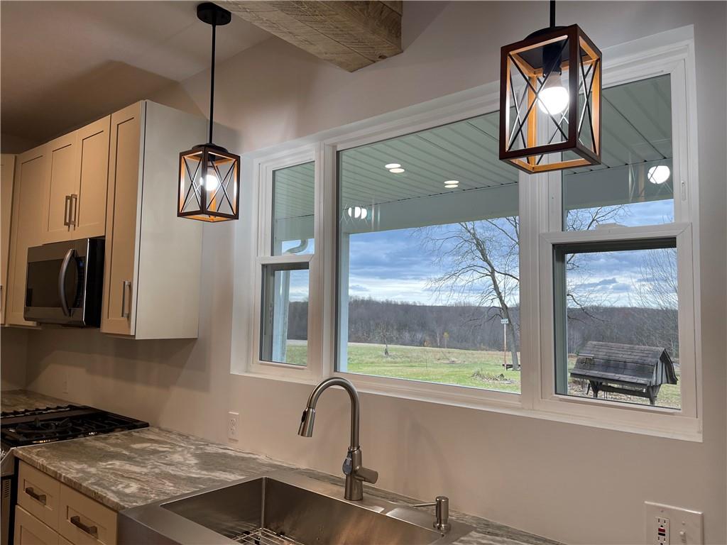 133 Weston Road Grove City, PA 16127 - Photo 35 of 44 Kitchen sink overlooking the peaceful back yard through the large window. Light fixtures are true farmhouse style.