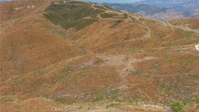 a view of a dry yard with mountains in the background