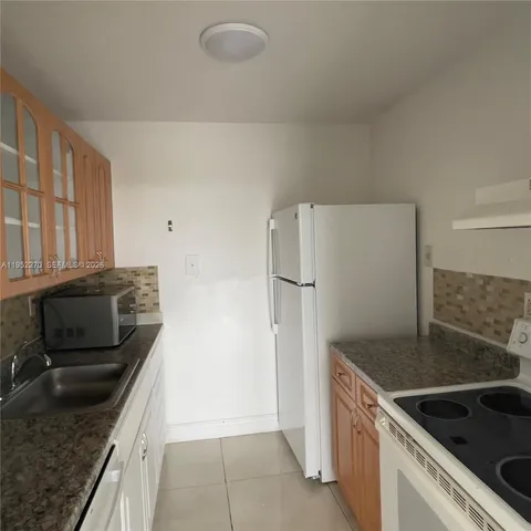 a kitchen with granite countertop a sink and stainless steel appliances