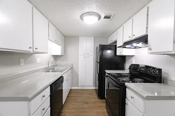 a kitchen with a sink dishwasher a stove and a refrigerator