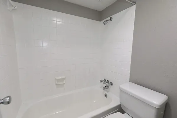 a white bath tub sitting next to a white toilet