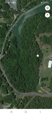 a utility room with water heater and wooden floor