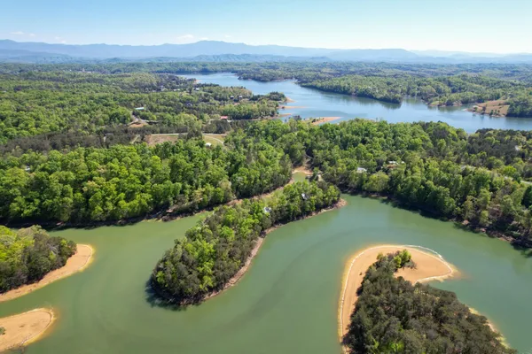 an aerial view of a golf course with a lake view
