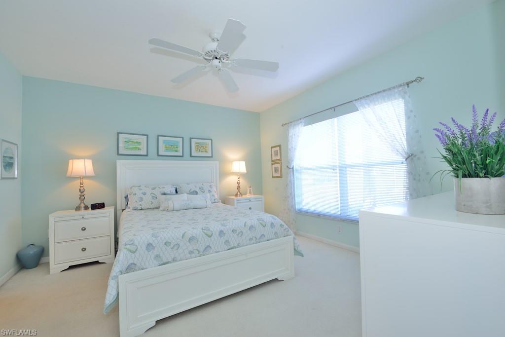 4960 Deerfield Way, Unit E102 Naples, FL 34110 - Photo 11 of 19 a bedroom with a bed and a window