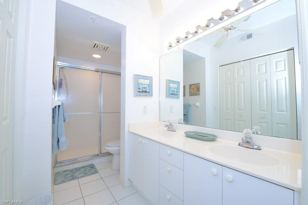 4960 Deerfield Way, Unit E102 Naples, FL 34110 - Photo 12 of 19 a bathroom with a double vanity sink mirror and shower