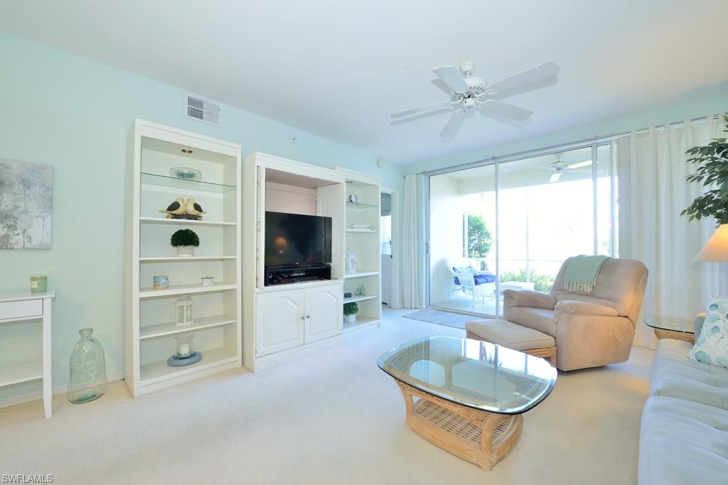 4960 Deerfield Way, Unit E102 Naples, FL 34110 - Photo 5 of 19 a living room with furniture and a flat screen tv
